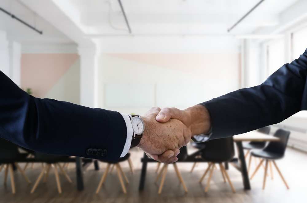 Two men shaking hands after a job interview in an inbound recruiting context.